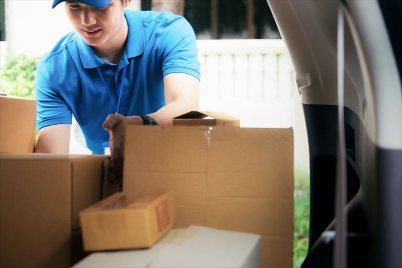 荷物を確認する男性スタッフ_R